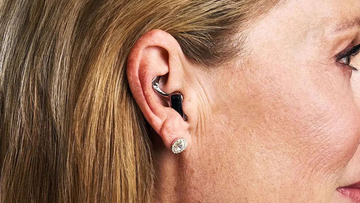 Nahaufnahme von dem Ohr einer Frau. Sie trägt ein Im-Ohr-Hörgerät.